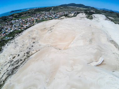 Arka planda bitki örtüsü ve gölü olan kum tepeleri, Ribanceira, Ibiraquera, Santa Catarina, Brezilya