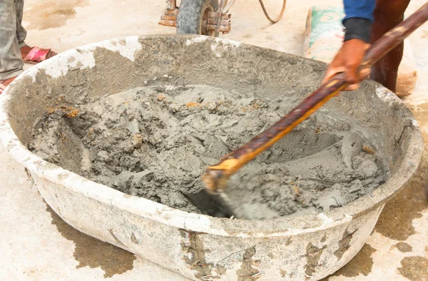 Builder arbetare under med hoe för att blanda våt cement — Stockfoto
