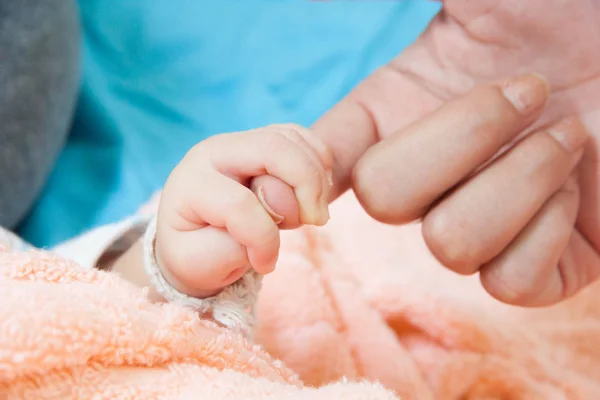 Tangan bayi memegang ibu jari — Stok Foto