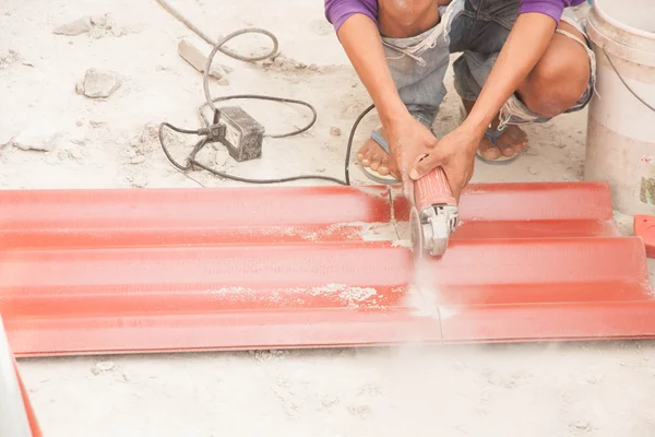 Trabajador de la construcción está cortando techo de azulejos — Foto de Stock