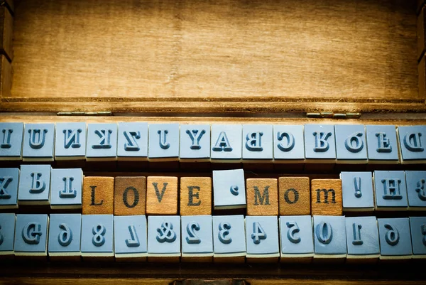 Amor mãe ortografia com selo de borracha na caixa de madeira — Fotografia de Stock