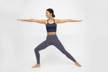 Asian woman doing yoga practices Ashtanga Vinyasa Yoga asana Virabhadrasana 2 or warrior pose 2 isolated on white background