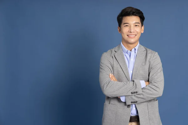 Smiling Young Asian Businessman Arms Crossed Blue Studio Isolated Background — Foto Stock