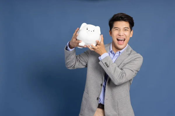 Portrait Happy Asian Businessman Holding White Piggy Bank Isolated Blue —  Fotos de Stock