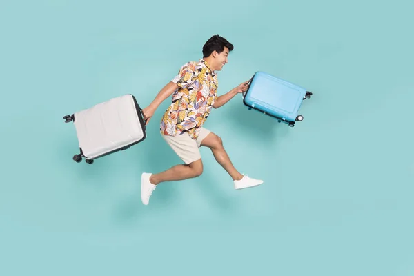 Happy Asian Man Traveler Jumping Holding Suitcase Isolated Green Background Foto Stock