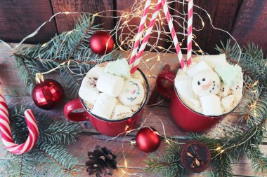 İçinde krema ve krema olan bir fincan kahve, ladin dalları, ahşap bir arka planda süslemeler ve aydınlatma, Noel, yeni yıl, ev konforu, tebrikler, 