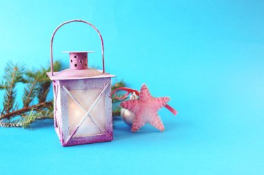 Noel, yanan mumlu fener, parlak bir arka planda köknar ağacı dalları ve balolar, yılbaşı tebrikleri, kartpostal konsepti.