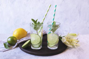 Narenciye suyu, nane yaprağı ve bardaktaki salatalık dilimleri hafif arka planda, sağlıklı içecekler, kilo vermek için su.