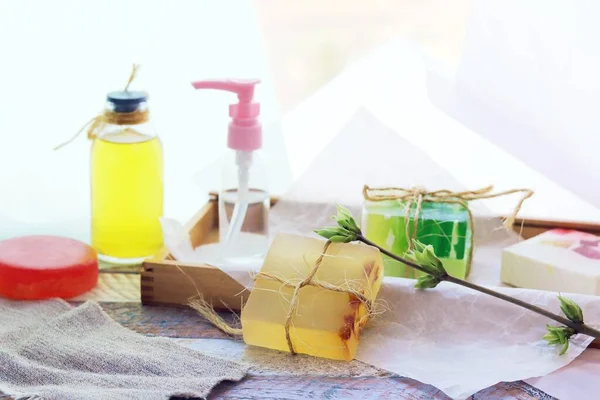 Handmade soap, spray, aromatic oil and healthy tinctures on a wooden table, the concept of cleanliness, hygiene, health, body care, gift wrapping