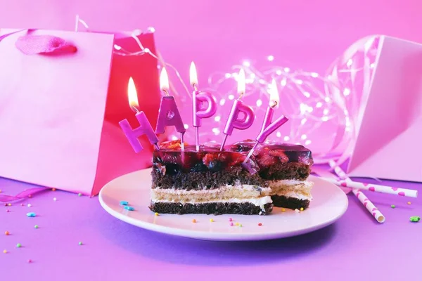 幸せなキャンドルを燃やすチョコレートケーキ 明るいピンクとライラックパープルの背景に照明 誕生日 お祝いのコンセプト ポストカード — ストック写真