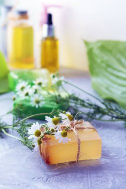 Natural soap, skin care products, oils, tinctures and chamomile flowers on the table, the concept of cleanliness, healthy lifestyle, body care