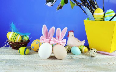 Paskalya yumurtaları ve geleneksel süslemeler ahşap bir masa üzerinde, bahar doğasının arka planına karşı.