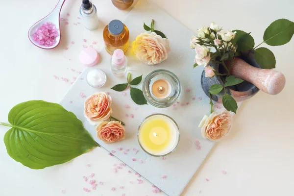 新鲜的粉红玫瑰 燃烧的蜡烛 淡淡的背景下的油和调味品 健康的生活方式 家庭化妆品 芳香疗法 浪漫的心情 替代疗法 免版税图库照片