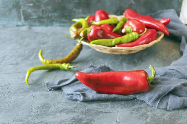 Grüne Und Rote Paprika Einem Weidenkorb Auf Einem Betontisch Und — Stockfoto