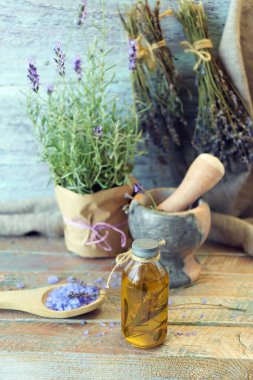 Yararlı bitkiler, yağlar ve tentürler, lavanta çiçekleri ve biberiye bir tencerede, ahşap arka planda, doğal malzemeler, alternatif tıp