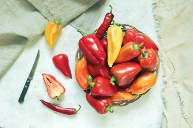 Basket with ripe peppers, on the table, top view, flat lay, natural organic products, harvest