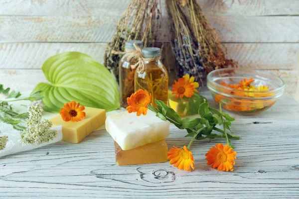 Calendula flowers, soap, oils and tinctures, on a wooden background, natural ingredients, alternative medicine