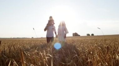 Mutlu genç aile güneşli bir yaz gününde dışarıda birlikte vakit geçiriyor..