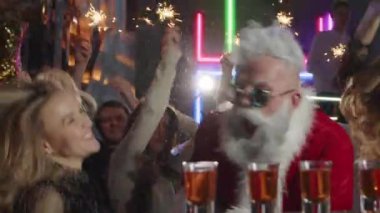 Modern Noel Baba barda gülümseyen güzel kızlarla içki içer..