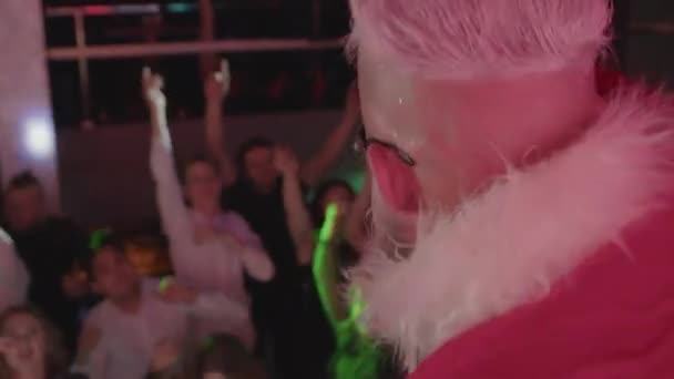 Santa Claus having fun with cheerful energetic crowd, waving hands and dancing. — Stock Video