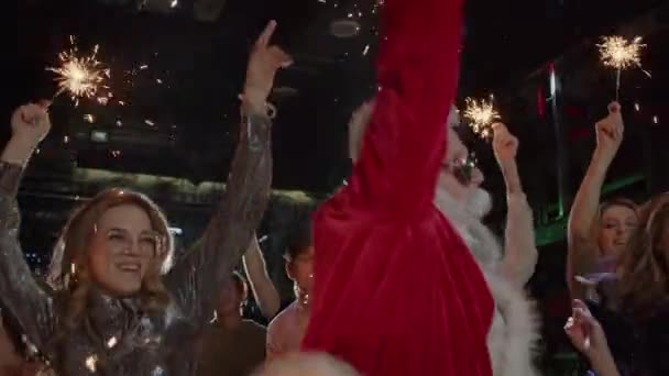 Gelukkig jonge mensen, Santa Claus dansen op kostuum Nieuwjaar feest — Stockvideo