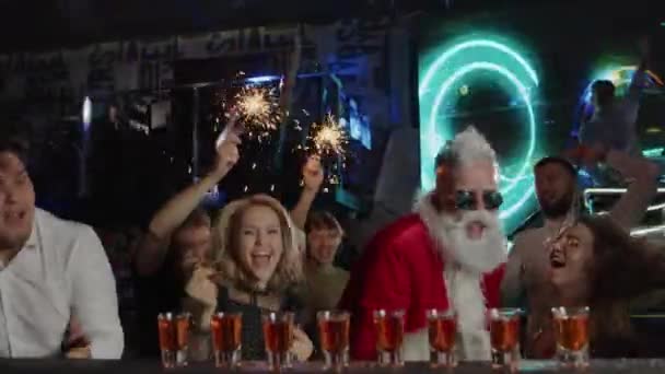 Счастливые люди, Санта-Клаус пьет алкоголь в клубном баре, празднует Новый год — стоковое видео