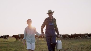 Gülümseyerek yaz yürüyüşü Mutlu torun ve büyükbaba tarlada ineklerle.