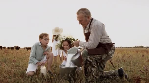 Happy rodinná farma procházka: starý muž, děti spolu pít zdravé přírodní mléko — Stock video