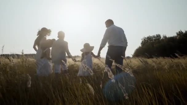 Здоровая счастливая семья, наслаждающаяся летней природой вместе на открытом воздухе в пшеничном поле. — стоковое видео