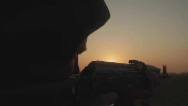两名携带武器的武装人员在作战行动后穿过战场，后视镜. — 图库视频影像
