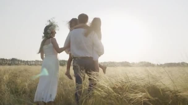 Pais felizes com filhas desfrutando de tempo juntos no campo amarelo no verão. — Vídeo de Stock