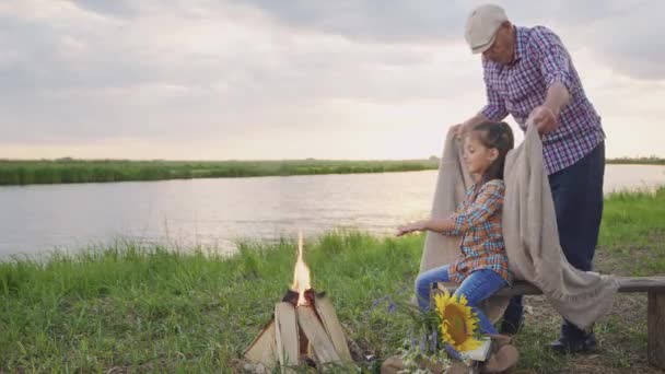 Affectionate Old Grandfather Covers Blanket Little Smiling Granddaughter Sitting Bonfire — Video