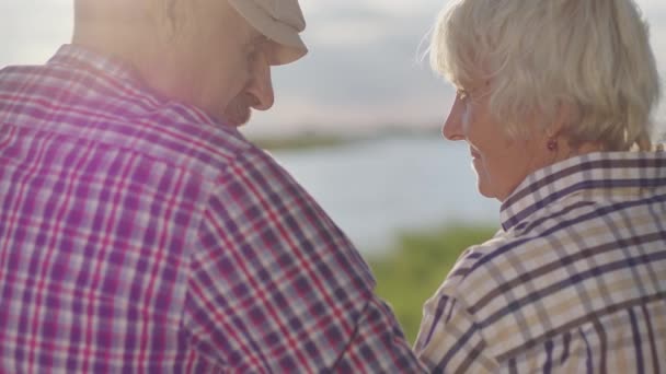 Happy Old Couple Together Embracing Sitting Lake Beach Sunshine Outdoors — Stockvideo