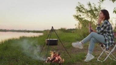 Adult woman do relaxing enjoy sitting in lotus position on boardwalk, deep enjoys physical, mental relax with closed eyes near water outdoors alone for calm mind. Practice asana exercise for wellness
