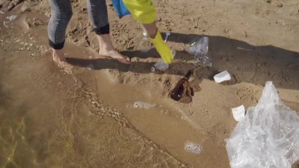 Female Volunteer Tries Avoid Water Contamination Picking Trash Wet Sand — Stock video