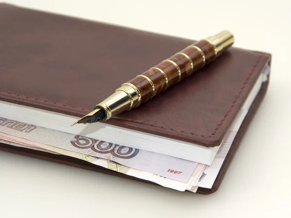 Money inside the diary, and pen — Stock Photo, Image