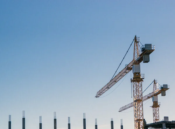 Een paar van de bouw van kranen op blauwe hemel — Stockfoto