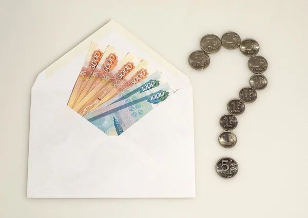 Pengar i kuvert och frågetecken från mynt — Stockfoto