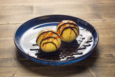 Tatlı soslu dondurma topları ve tepside çikolata şurubu.