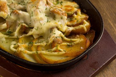 Az pişmiş et ve patatesleri yakından izleyin.