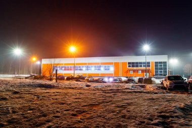 Şehir yüzme havuzu binası, bahar akşamları sis içinde arabaları park etmek. Petrozavodsk, Rusya