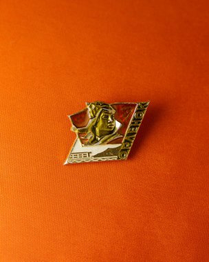 Kızıl öncü kravatının arka planında SSCB 'deki öncü kampı kartalının rozeti.