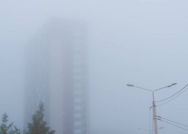 Yazın yoğun beyaz siste yüksek bina