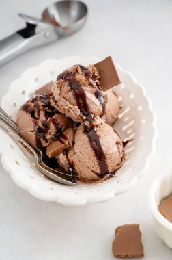 Çikolatalı dondurma topları, çikolata soslu kepçeler gri arka planda, yaz ziyafeti