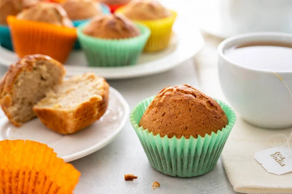 Bir fincan sıcak çayla servis edilen renkli kağıt bardaklı ev yapımı kek.