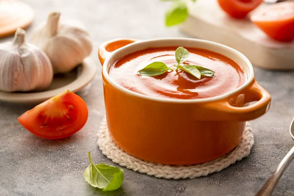 Turuncu kasede taze fesleğenli domates çorbası. Parlak bir arka plan. Sağlıklı gıda konsepti.