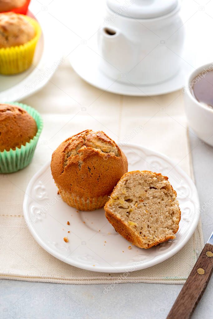 Homemade muffin with colorful paper cups, in a plate served with cup of hot tea