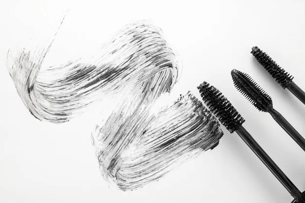 Fırça aplikatörlü siyah rimel, beyaz arka planda izole edilmiş. Güzellik ürünleri