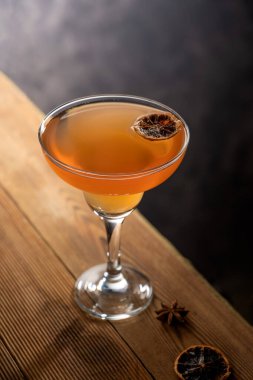 Fruit punch cocktail with rum, vanilla syrup and orange juice on wooden table