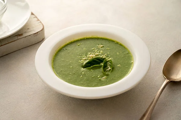 Spinach soup. Green creamy, vegan creamy soup on bright background.